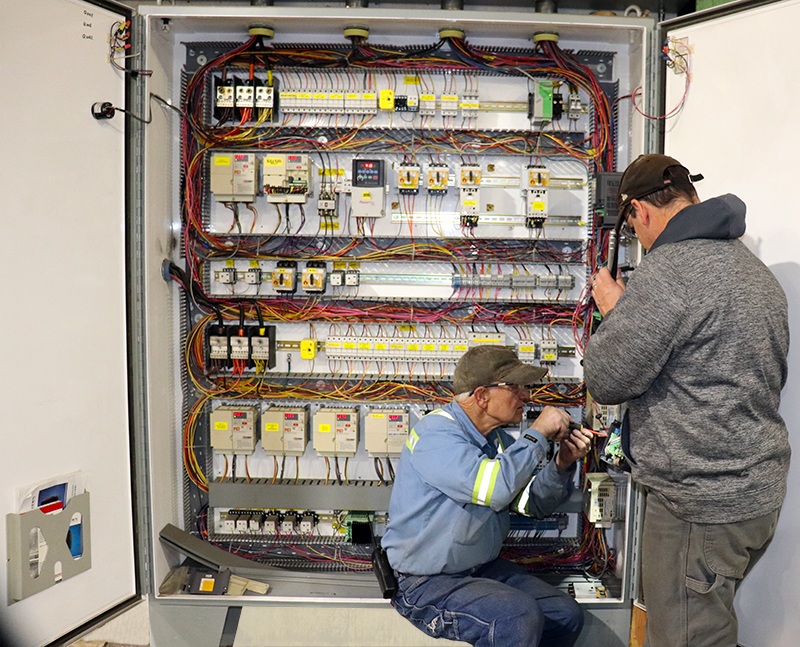 Electricians working on an electrical panel