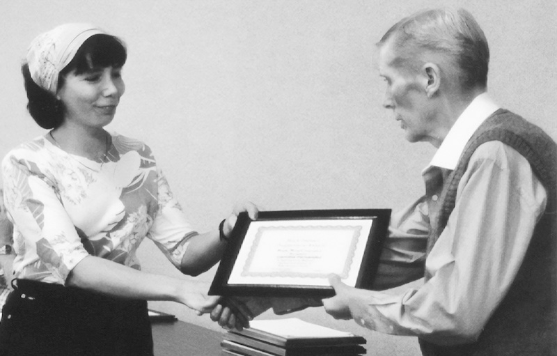 Camillia Fernandez accepts a high impact suggestion award from Bright Wood CEO/President Ken Stovall in 1994