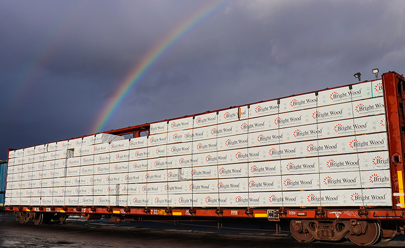 Rainbow over a rail car loaded with Bright Wood's engineered dimension lumber