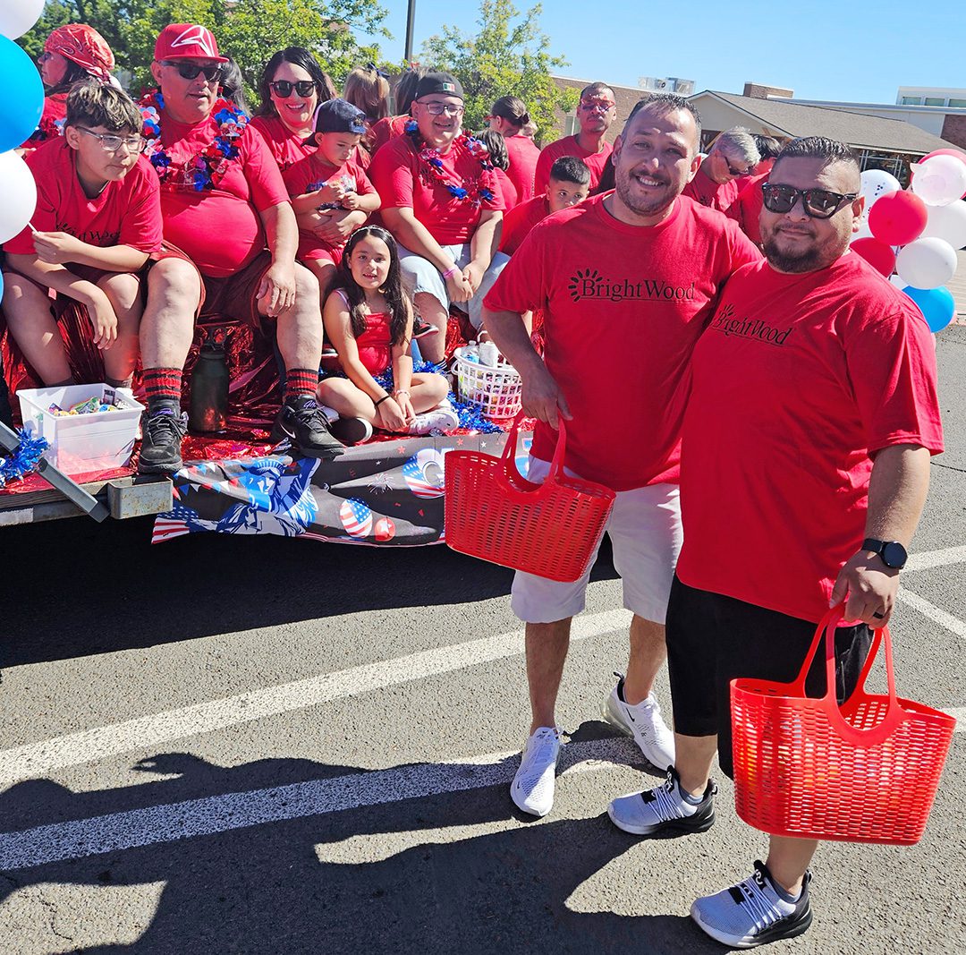 Two men with red baskets beside float